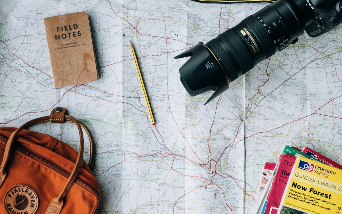 Travellers planning a trip with maps and documents